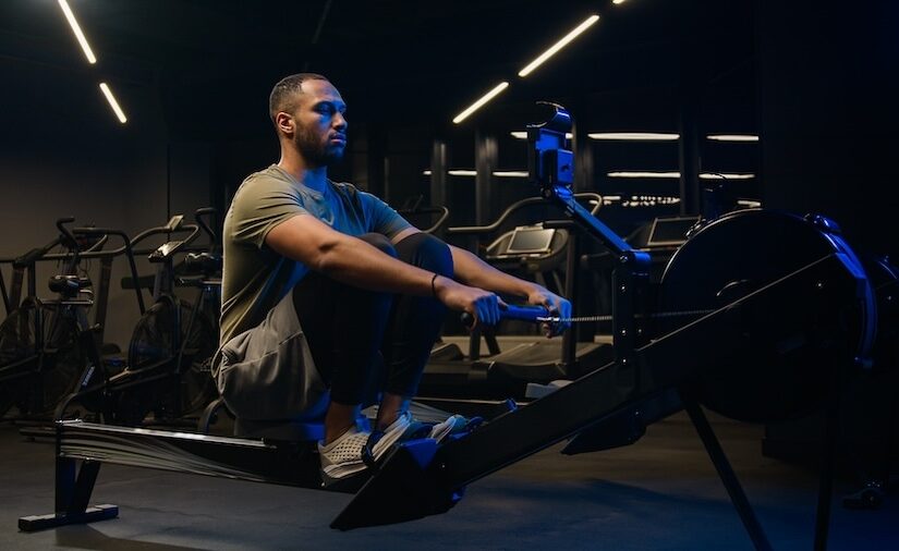 Sport hard weight exercise sporting bodybuilding workout gym pulling rowing machine sitting lift low row motivation healthy African American man sporty male guy athlete sportsman bodybuilder trainer