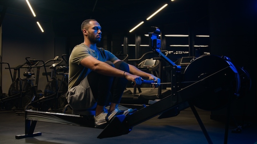 Sport hard weight exercise sporting bodybuilding workout gym pulling rowing machine sitting lift low row motivation healthy African American man sporty male guy athlete sportsman bodybuilder trainer